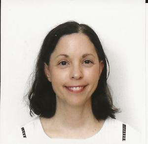 Marian Baker, a brunette woman, smiles at the camera.